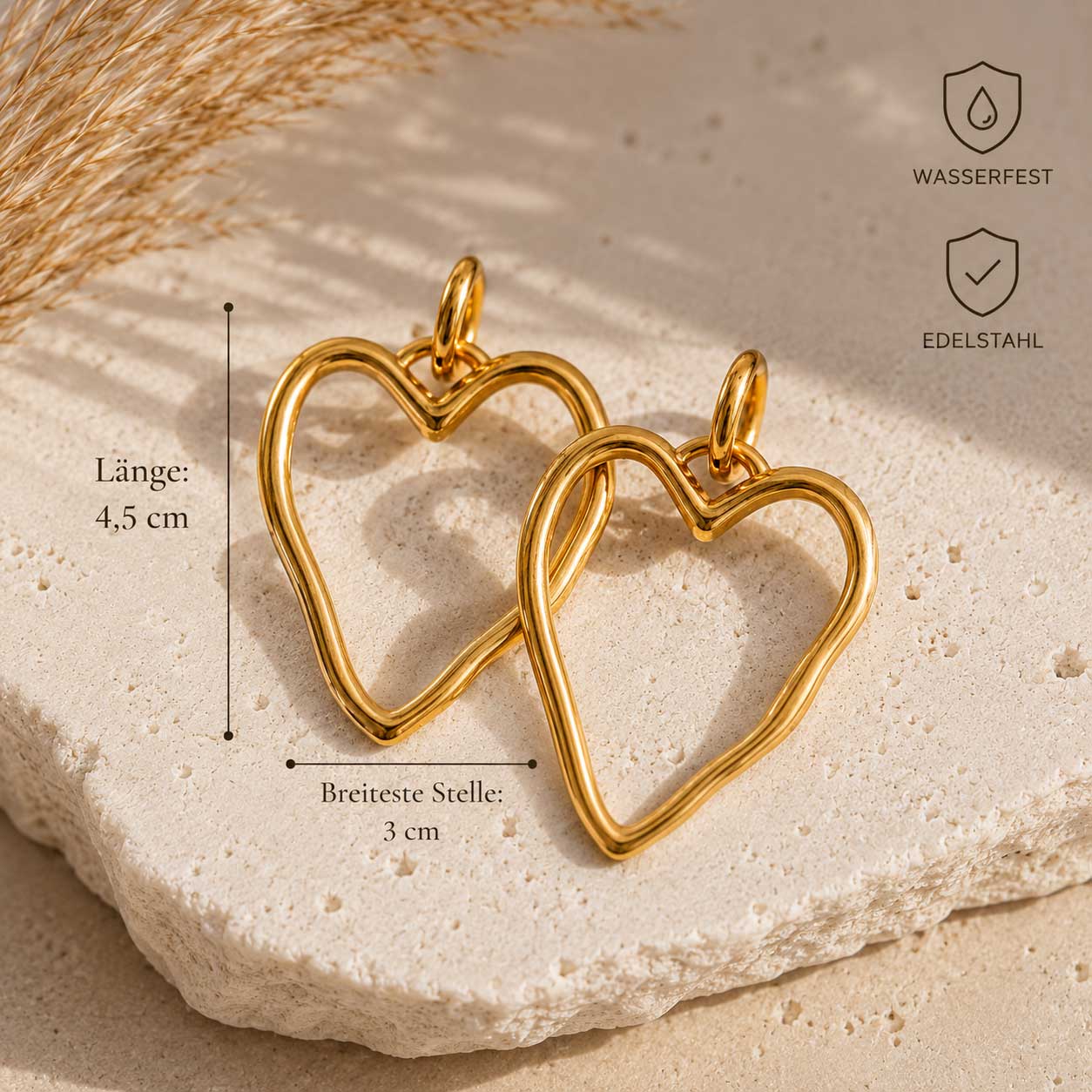 Heartline goldene Ohrringe aus Edelstahl mit Herzform, Maßangaben Länge 4,5 cm und Breite 3 cm sowie Hinweisen wasserfest und Edelstahl auf Travertin – Saltyblush
