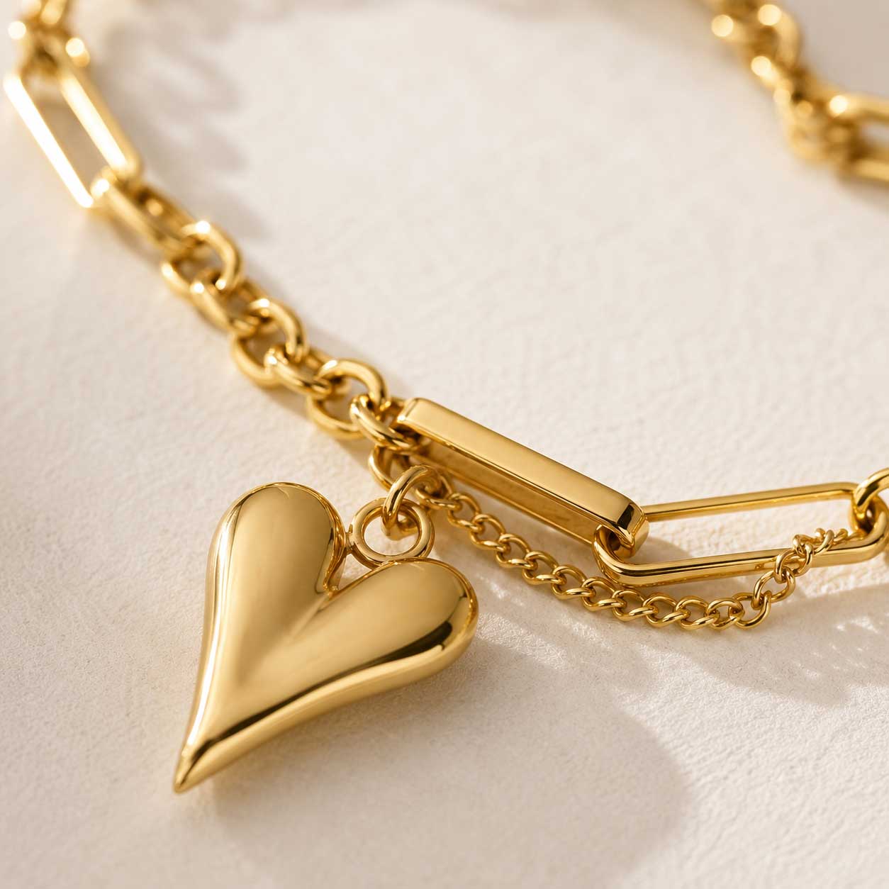 Nahaufnahme goldener Herzanhänger – Heartwave Armband von Saltyblush, glänzender 3D-Herzcharm an zweireihiger Goldkette, Detailansicht
