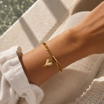 Heartwave Armband Lifestyle – goldenes Herzarmband von Saltyblush am Handgelenk, sommerlicher Look am Wasser, elegantes Schmuckstück
