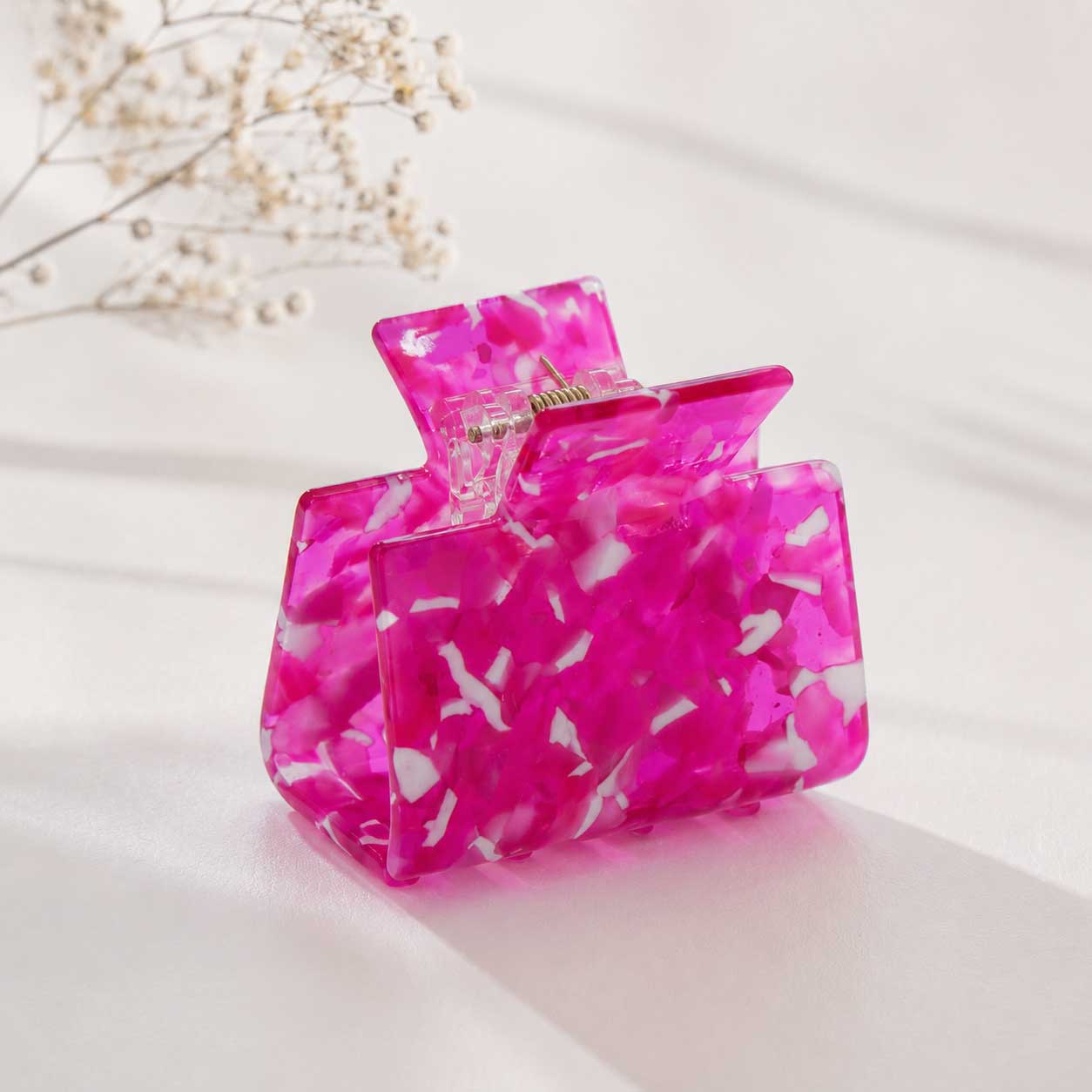 Hot Pink Crush Haarklammer aus Acryl in leuchtendem Pink mit weißem Marmor-Muster auf hellem Hintergrund mit Trockenblumen – Saltyblush
