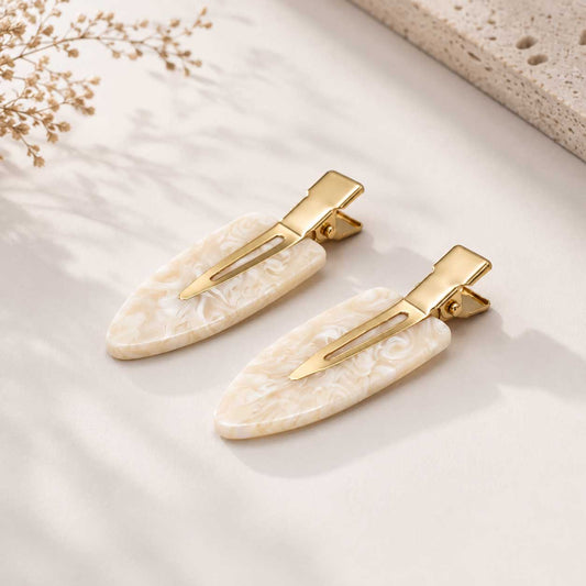 Ivory Pearl Haarclips – 2er Set, marmoriertes Weiß mit goldfarbenen Details, auf hellem Untergrund
