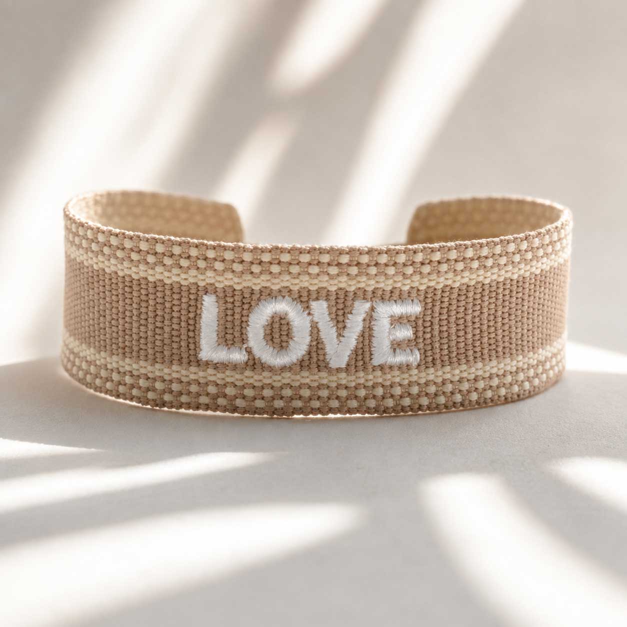 Love beiges Statement Armband mit weißem Schriftzug – gewebtes Cuff-Armband in Beige, Saltyblush
