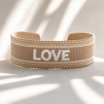 Love beiges Statement Armband mit weißem Schriftzug – gewebtes Cuff-Armband in Beige, Saltyblush
