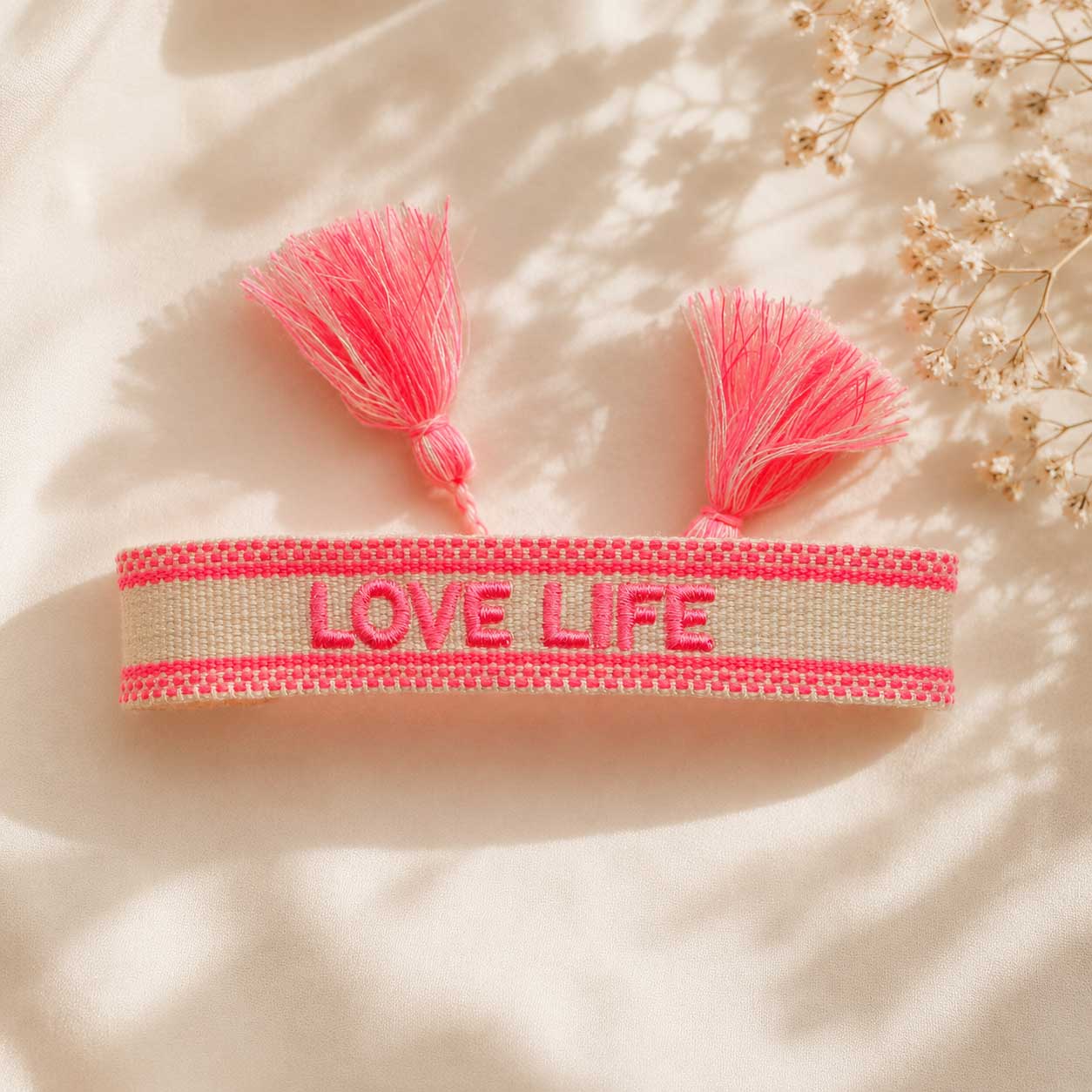Love Life Statement Armband aufgeklappt mit zwei pinken Quasten – Flatlay Produktfoto, Saltyblush
