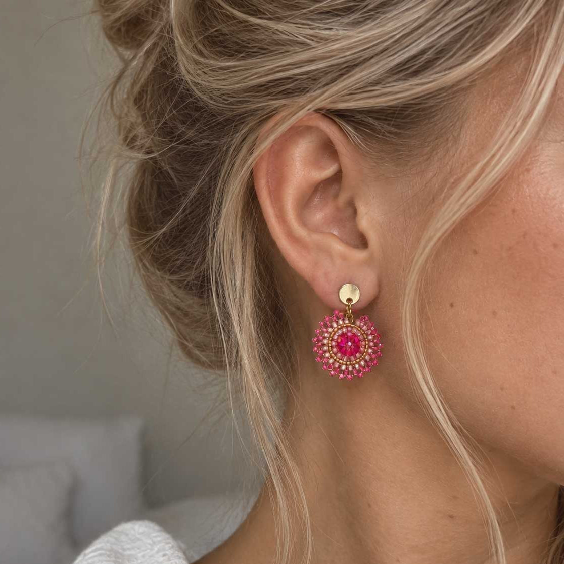 Mini Boho Bloom goldene Perlenohrringe in Pink am Ohr getragen – leichter Boho-Schmuck mit rundem Perlenanhänger
