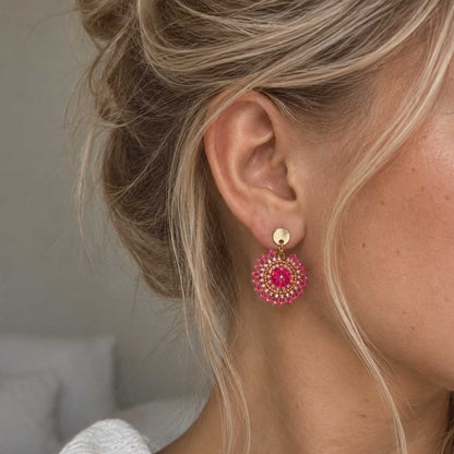 Mini Boho Bloom goldene Perlenohrringe in Pink am Ohr getragen – leichter Boho-Schmuck mit rundem Perlenanhänger
