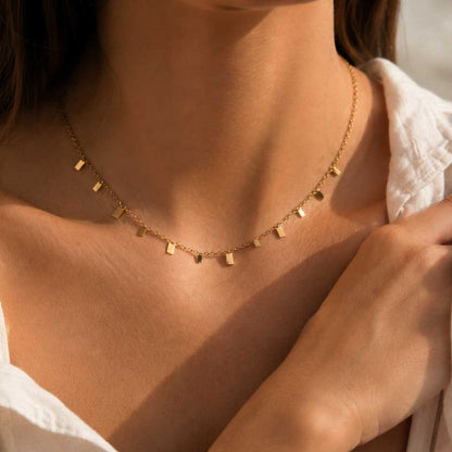 Minimalist Chic Halskette und Armband im Set – goldene Plättchen-Schmuck von Saltyblush, Layering-Look mit Halskette und passendem Armband, Lifestyle-Foto im Sonnenlicht
