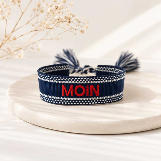 Statement Armband MOIN in Dunkelblau mit roter Stickerei und Quasten auf weißem Tablett – Saltyblush
