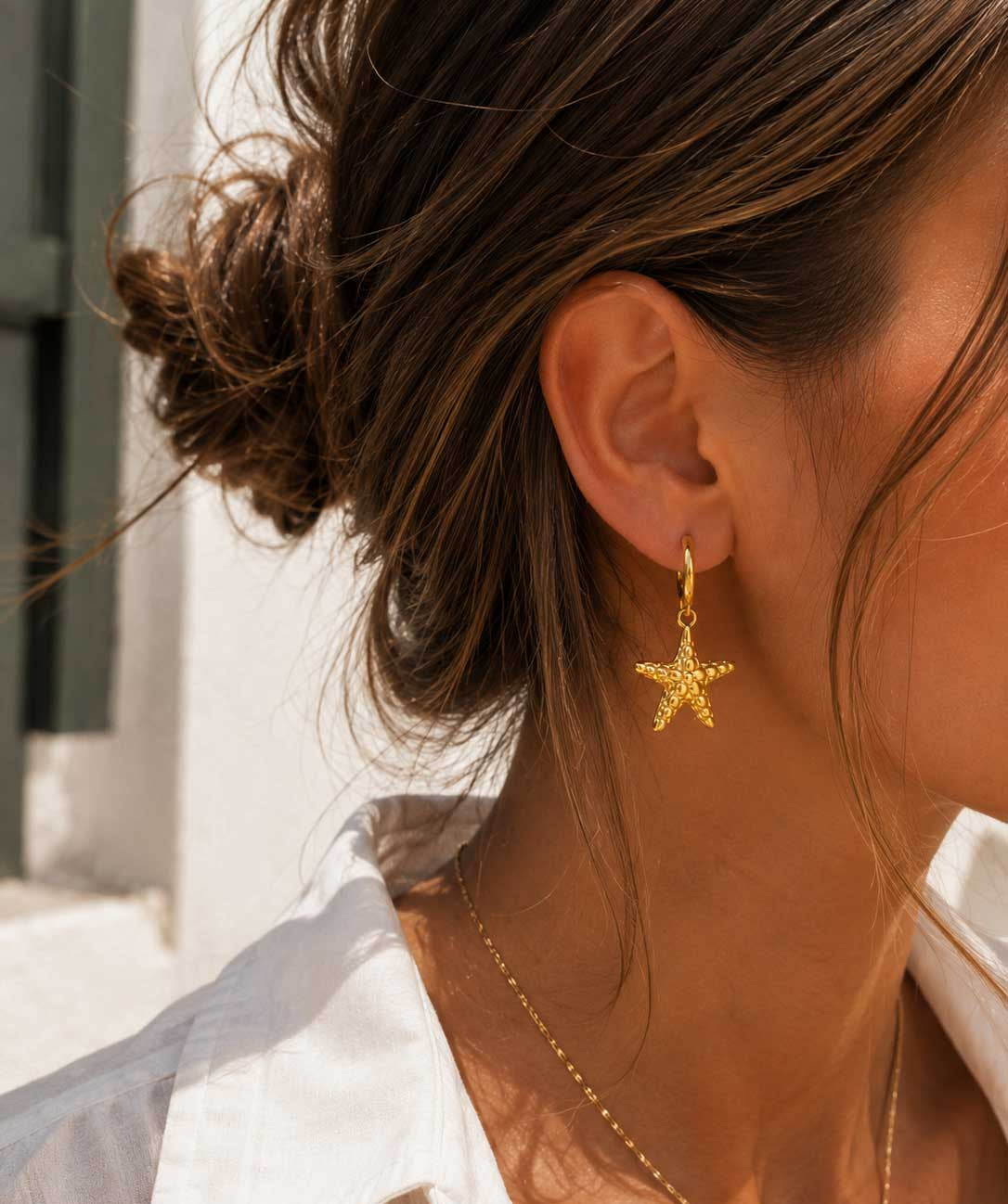 Ocean Star goldene Seestern-Ohrringe getragen – Lifestyle-Aufnahme im Sonnenlicht
