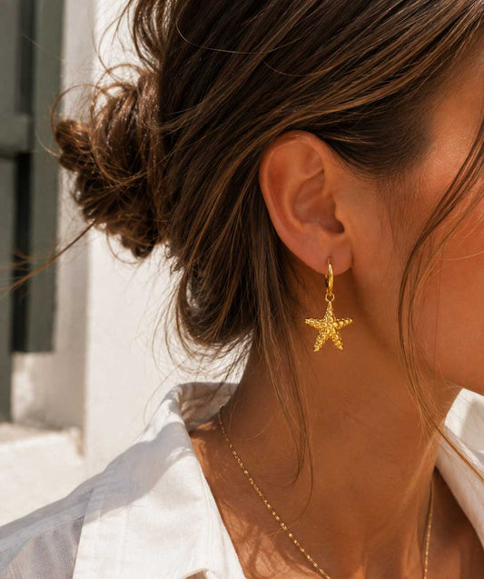 Ocean Star goldene Seestern-Ohrringe getragen – Lifestyle-Aufnahme im Sonnenlicht
