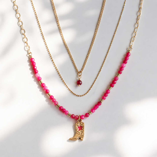 Dreiteiliges goldenes Layering-Halsketten-Set Pink Western mit pinken Perlen, rotem Kristallanhänger und Cowboy-Boot-Charm auf hellem Hintergrund – Saltyblush
