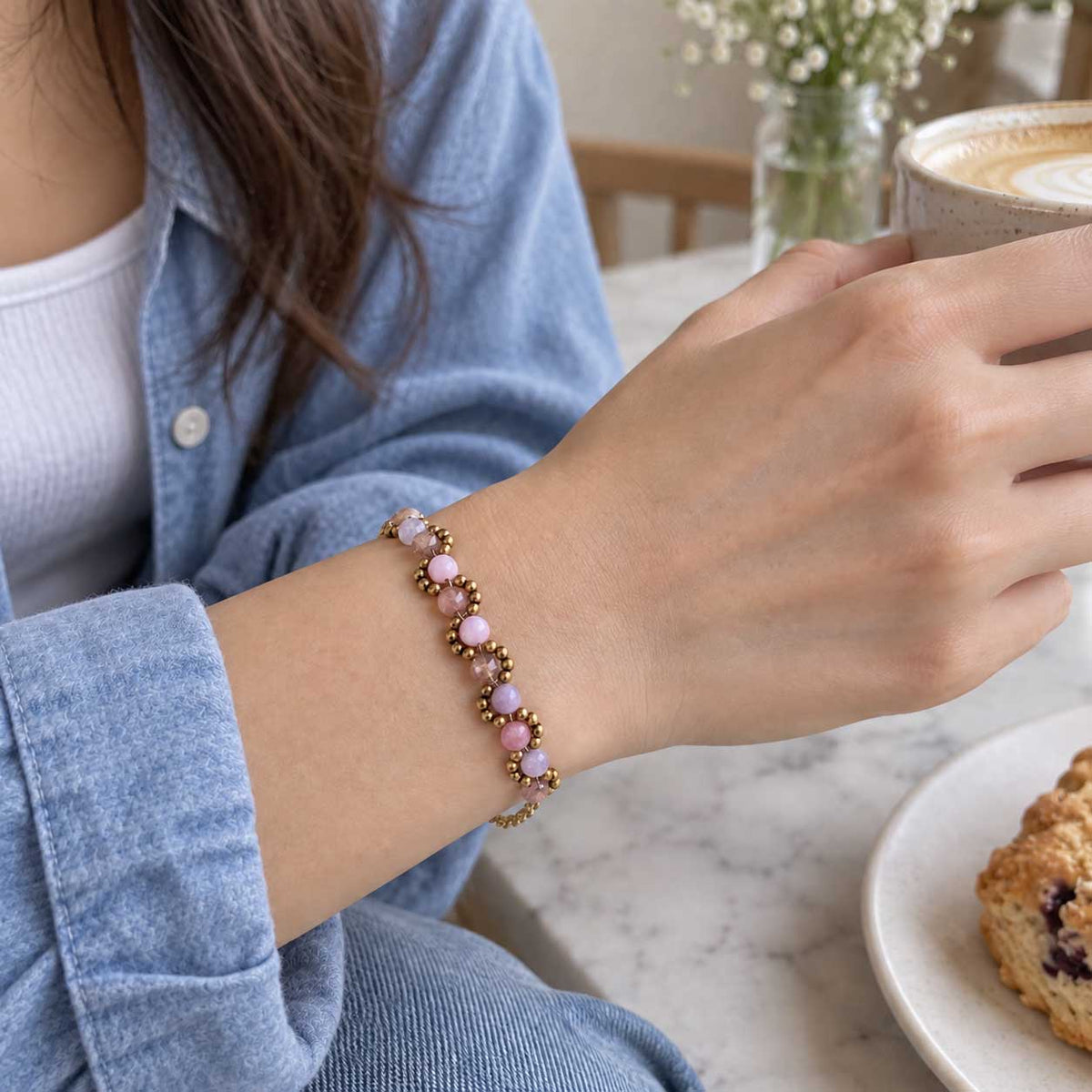 Goldenes Perlenarmband aus Edelstahl am Handgelenk getragen, mit zarten Perlen, verstellbarer Länge und elegantem Design für Alltag und Layering-Looks
[AI]

