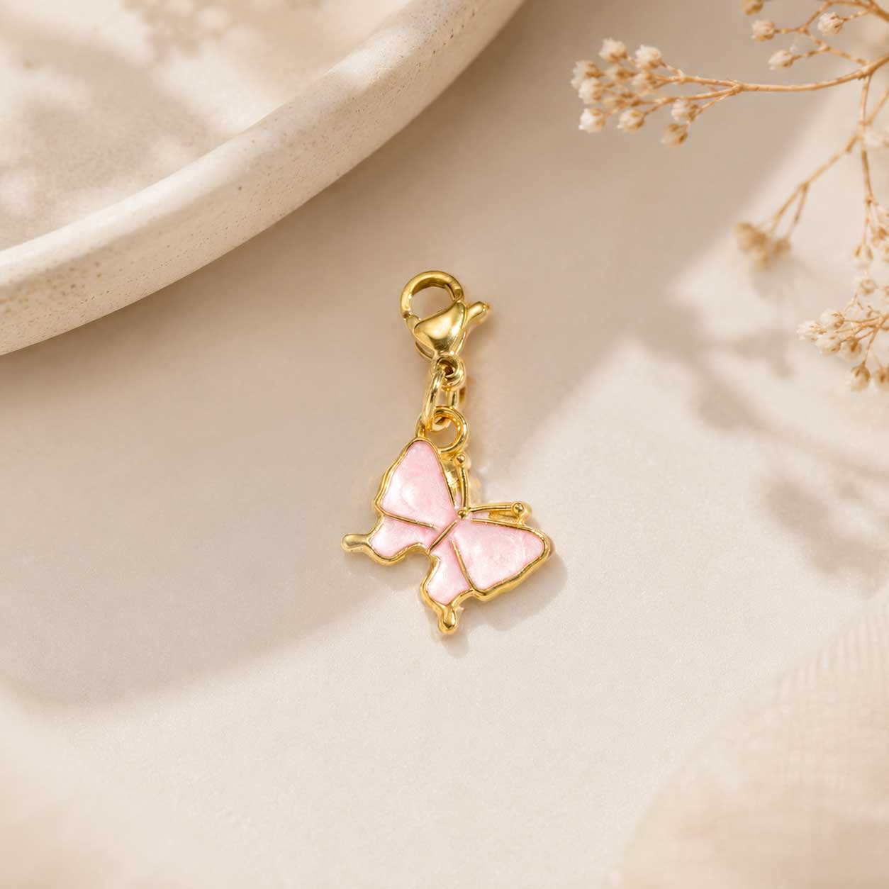 Rosaner Schmetterling-Charm mit goldenem Rand und Karabinerverschluss – filigran & feminin – Charm Concept Saltyblush
