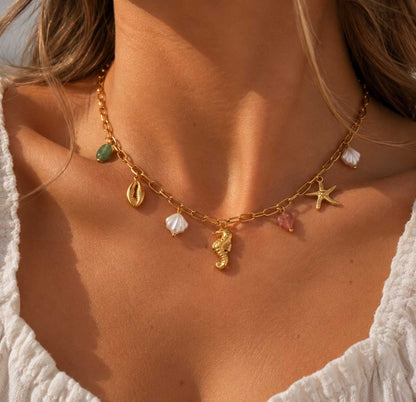 Sea Kiss goldene Halskette getragen – maritime Charms mit Seepferdchen, Seestern und Kaurimuschel im Sommer-Look
