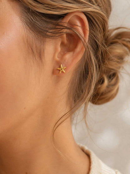 Sea Spirit Ohrringe getragen – goldene Seestern Stecker von Saltyblush am Ohr einer Frau mit blondem Haar, minimalistischer sommerlicher Look
