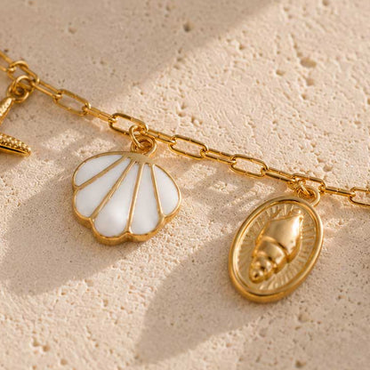 Nahaufnahme des weißen Muschel-Charms und goldenen Schnecken-Medaillons der Sea Whisper Fußkette aus Edelstahl – Saltyblush
