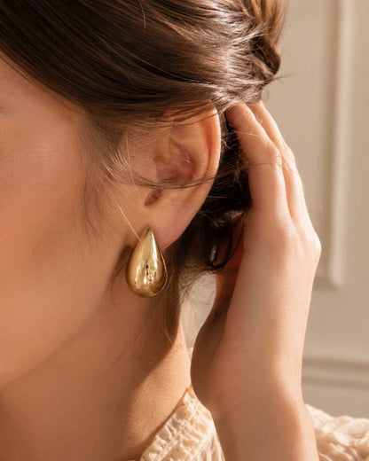 Frau trägt goldene Tropfen-Ohrringe Soft Glow Drop von Saltyblush – feminines Accessoire für Alltag und besondere Anlässe
