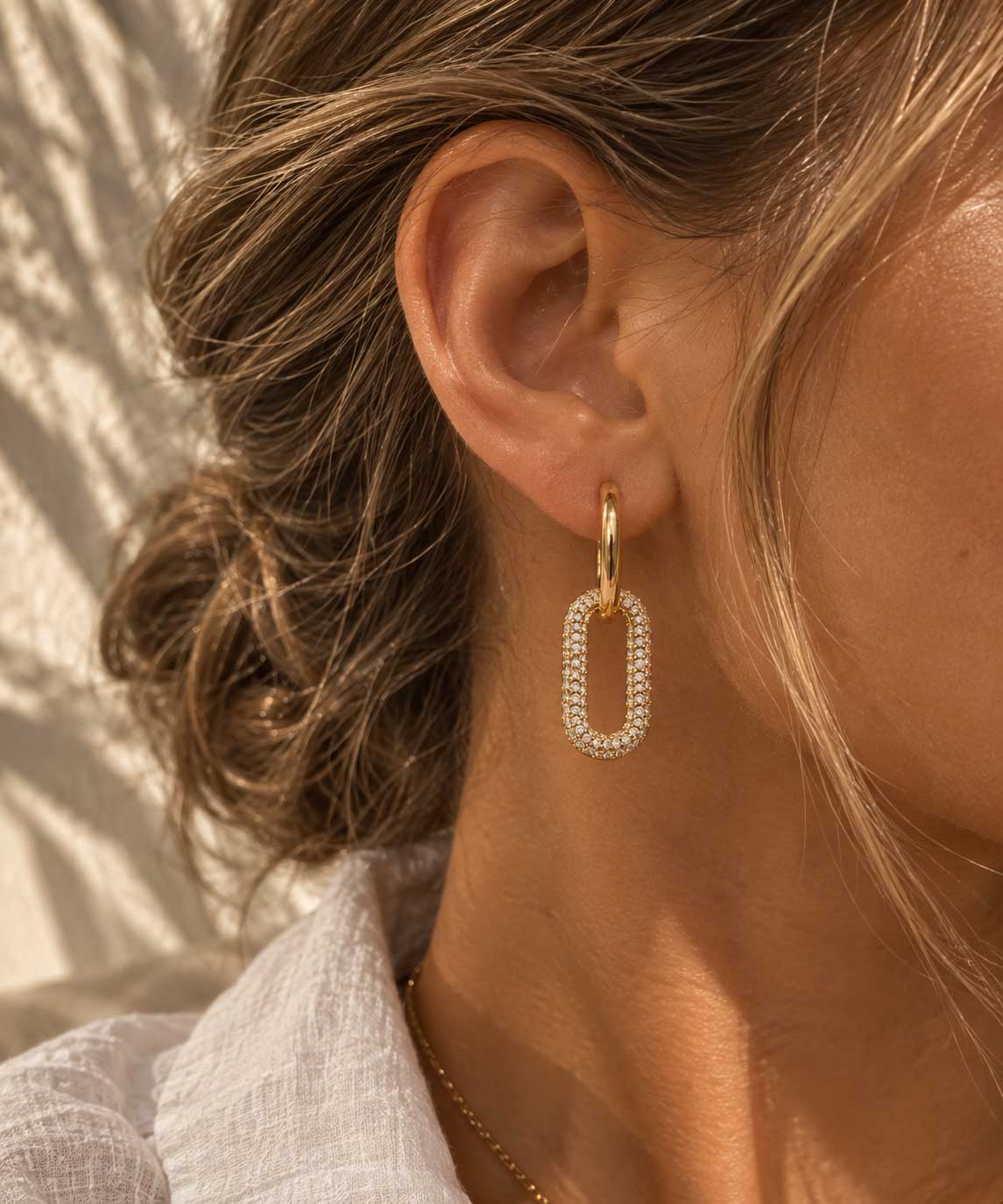 Nahaufnahme goldener Creolen mit ovalem Zirkonia-Pavé-Anhänger – Sparkle Hoops von Saltyblush
