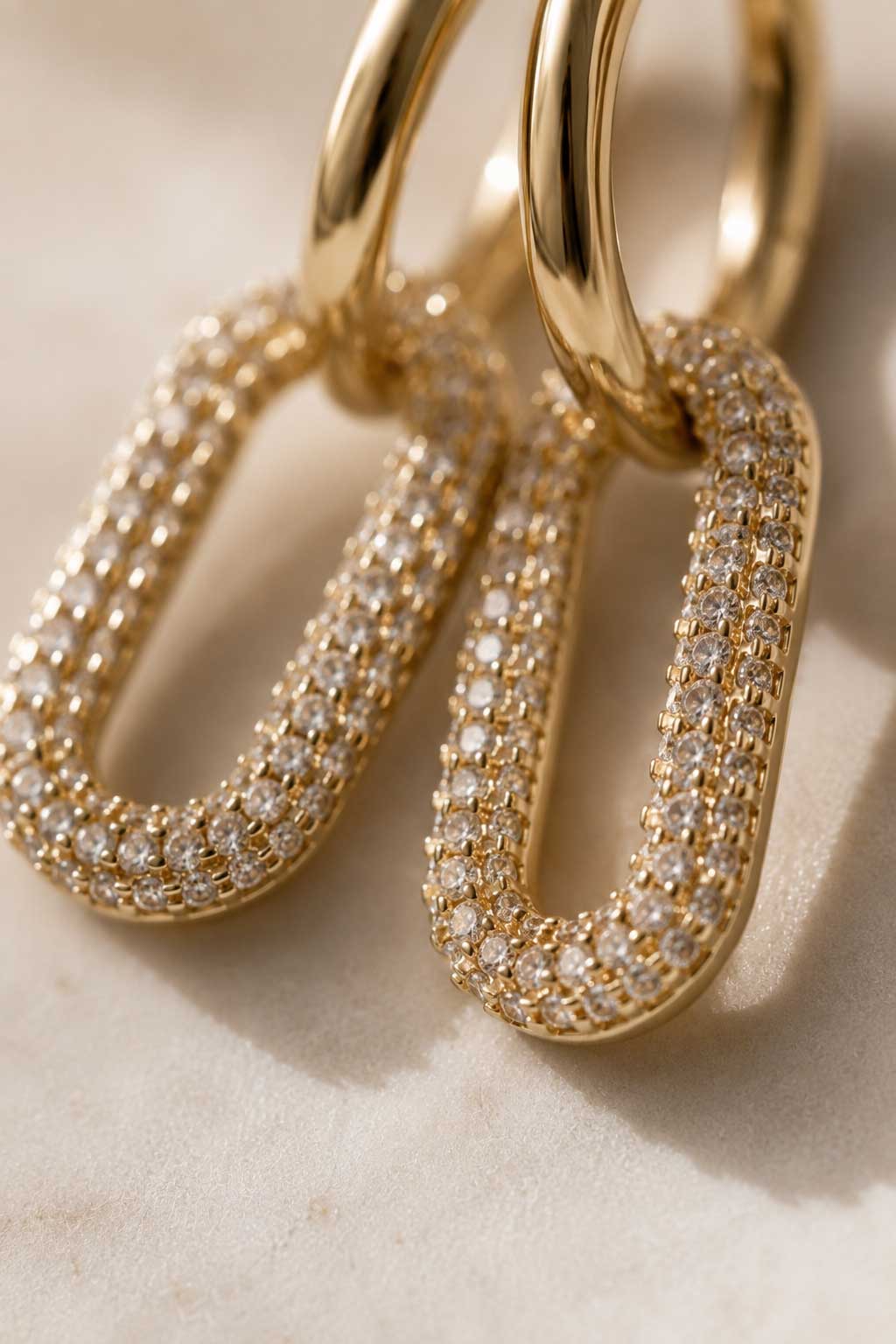 Goldene Sparkle Hoops Ohrringe am Ohr getragen im Sonnenlicht mit weißem Outfit – Saltyblush
